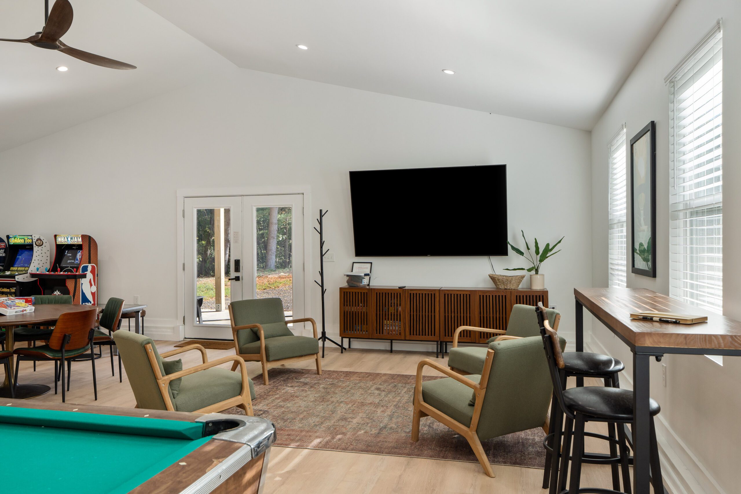 Game room lounge with 85-inch TV, pool table, and arcade machines at Notestone Reserve, Hocking Hills Ohio